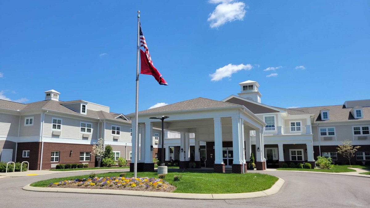 A well-maintained building with a flagpole, under a clear blue sky.