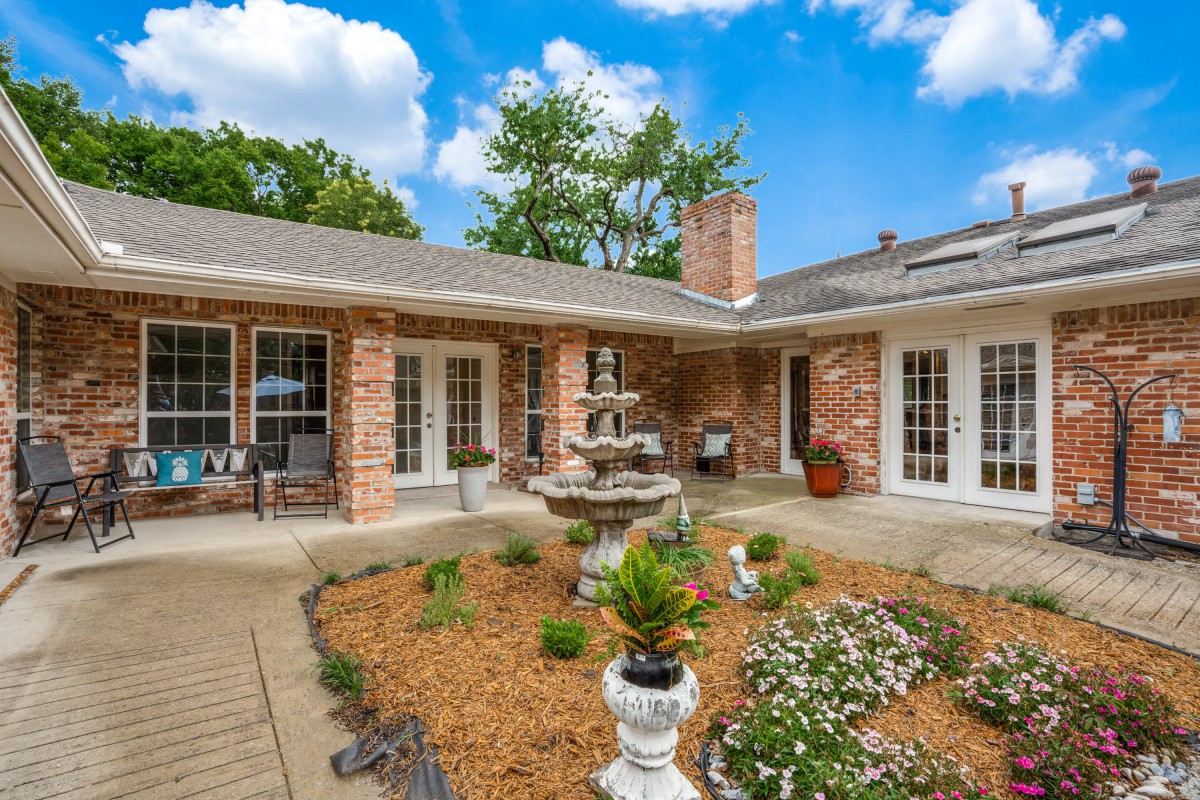 Charming brick house with a beautifully landscaped courtyard and fountain.