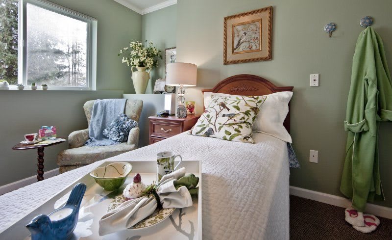 A cozy bedroom with a neatly made bed, decorative pillows, and elegant interior decor.