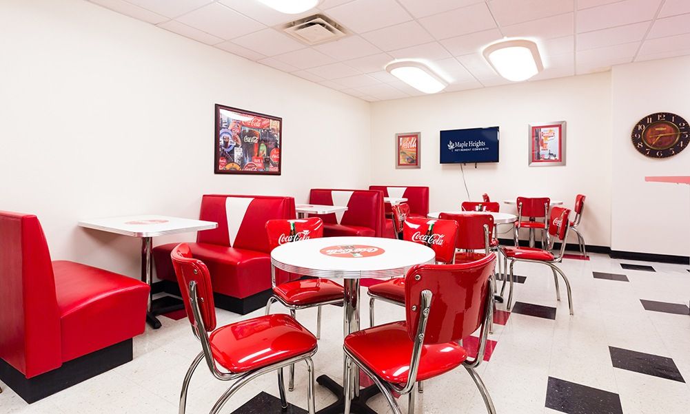 A retro diner interior with red chairs and booths, featuring vintage decor.