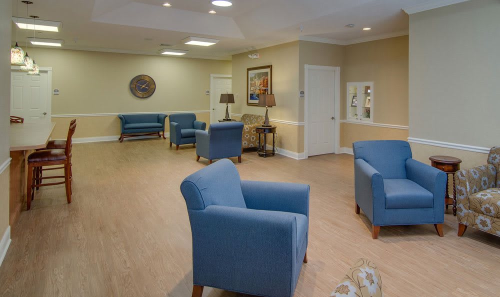 A spacious waiting area with comfortable blue chairs and warm lighting.