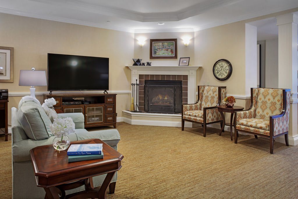 A cozy living room with a fireplace, television, and comfortable seating.
