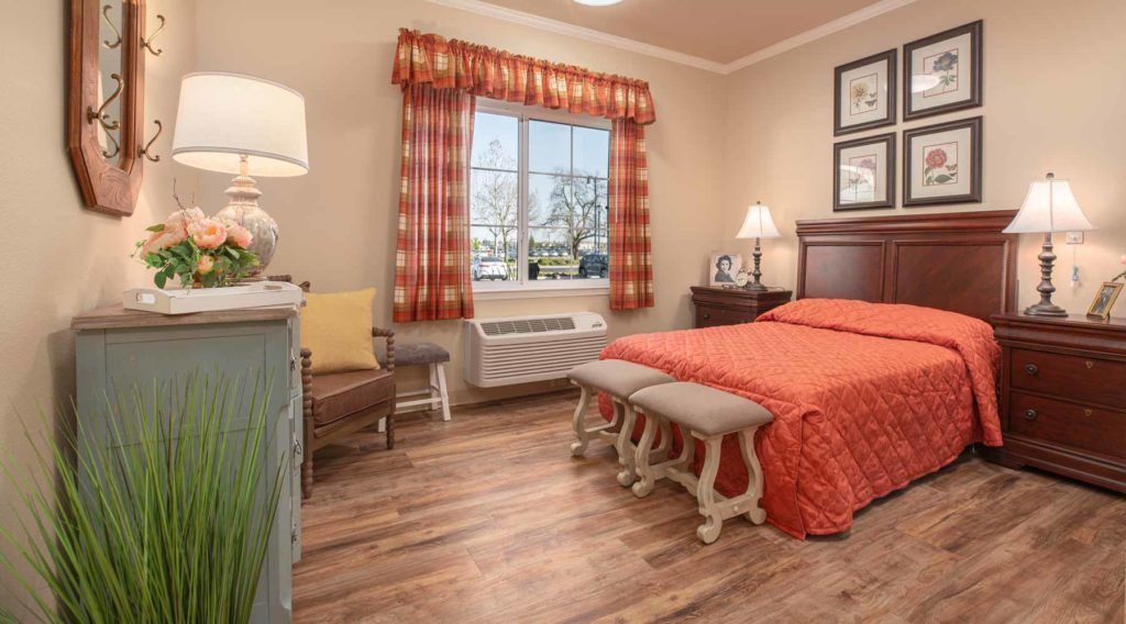 A cozy bedroom with warm decor and hardwood flooring.