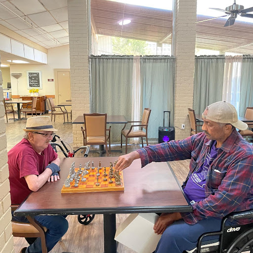 Two seniors engage in a friendly game of chess at a community center.