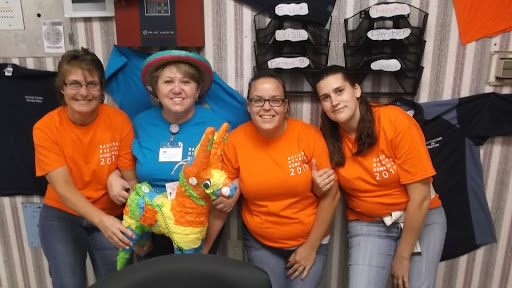 A cheerful group of participants posing with a colorful piata at an event.