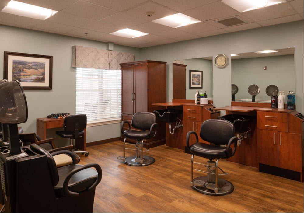 An interior view of a hair salon with chairs and mirrors.