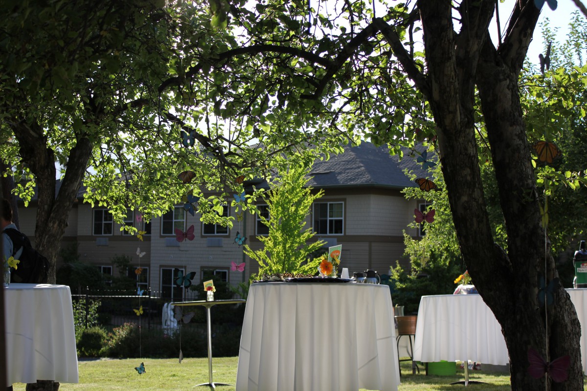A beautifully set outdoor event with tables in a garden setting.