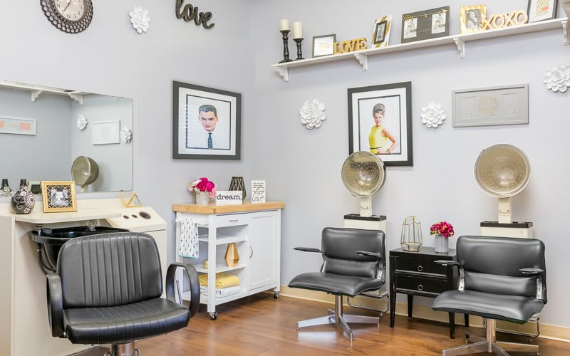 A cozy hair salon interior with stylish decor and comfortable seating.