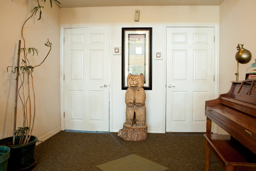 A cozy entrance featuring double doors, a mirror, and a wooden sculpture as decor.
