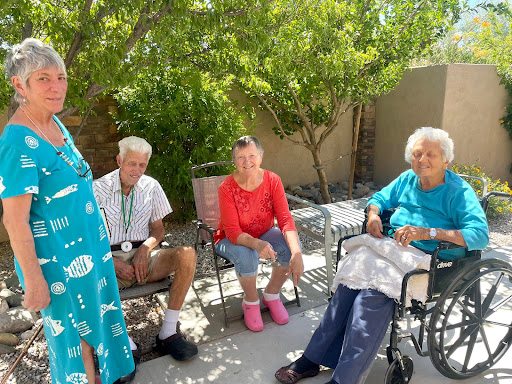A group of seniors enjoying a sunny afternoon outdoors, engaged in conversation.