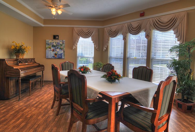 A cozy dining room with a set table and large windows.
