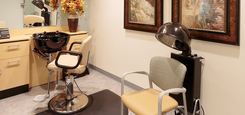 Interior view of a salon featuring chairs and a hair dryer.
