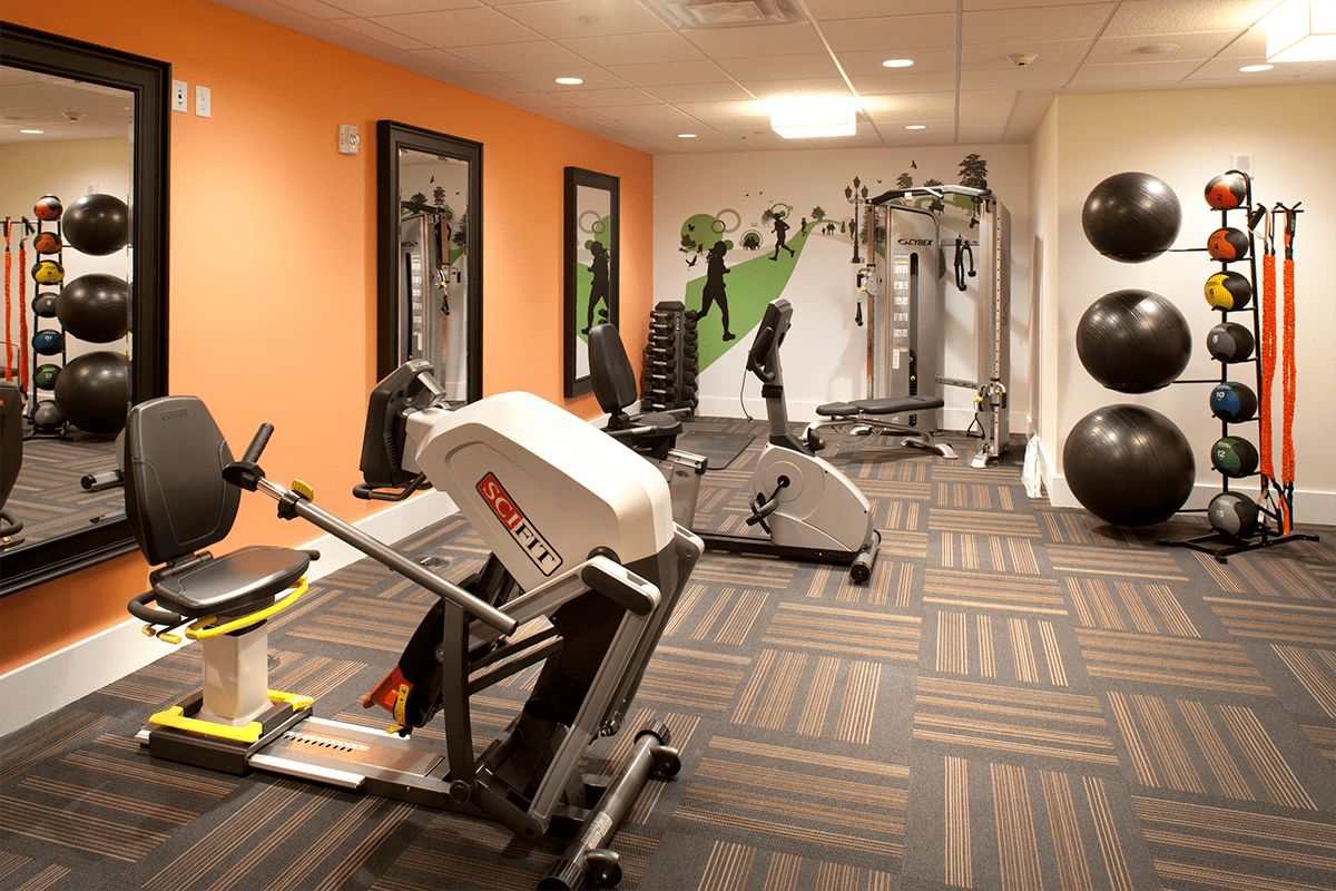 A modern gym with various exercise equipment and vibrant decor.
