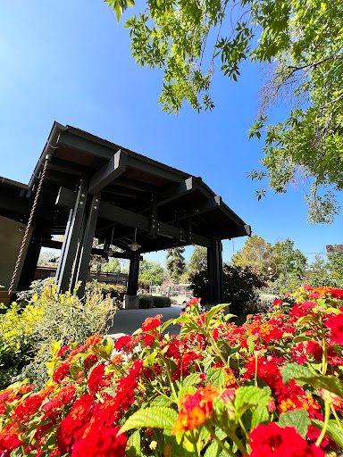 A serene view of a structure surrounded by vibrant flowers under a clear blue sky.