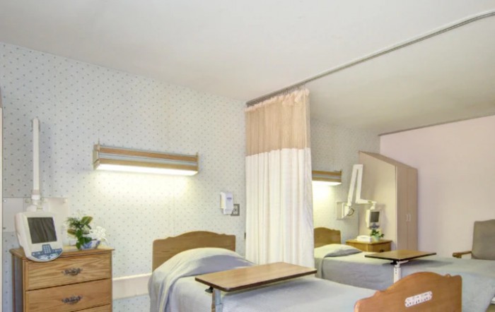 A hospital room with a single bed and a privacy curtain.