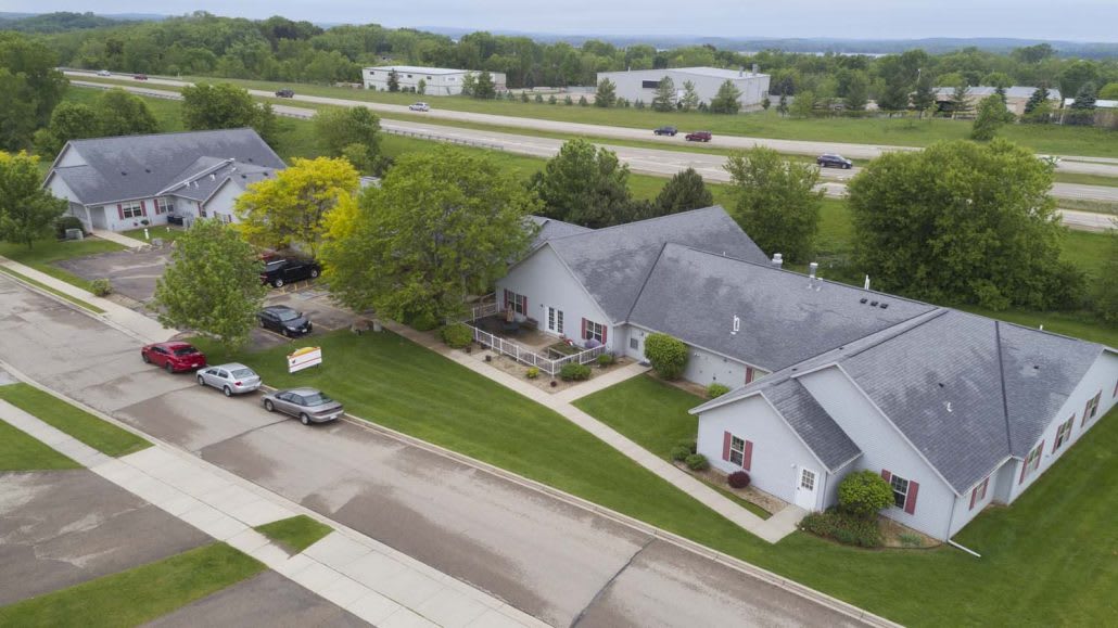 Aerial view of a residential neighborhood with houses, roads, and green spaces.