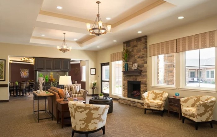 A modern living room with stylish furniture and a stone fireplace, featuring decorative ceiling lights.