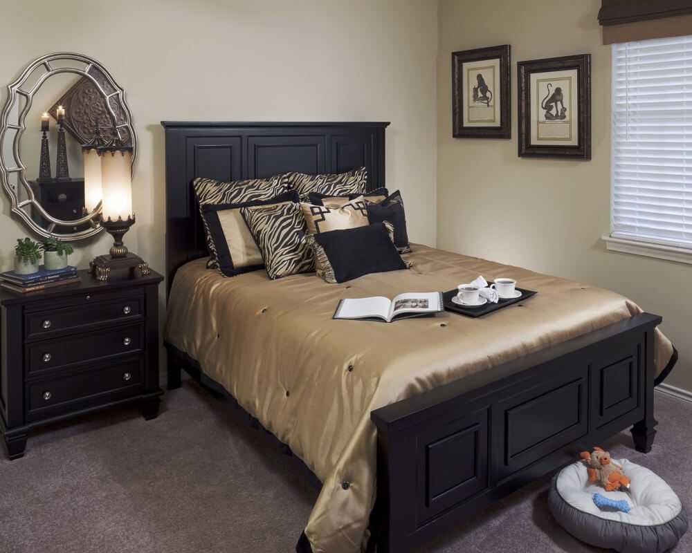 A cozy bedroom with elegant dark furniture and decorative pillows.