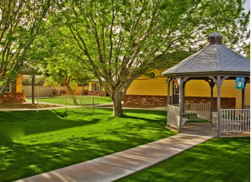 A serene outdoor park featuring a gazebo surrounded by lush greenery and well-maintained pathways.