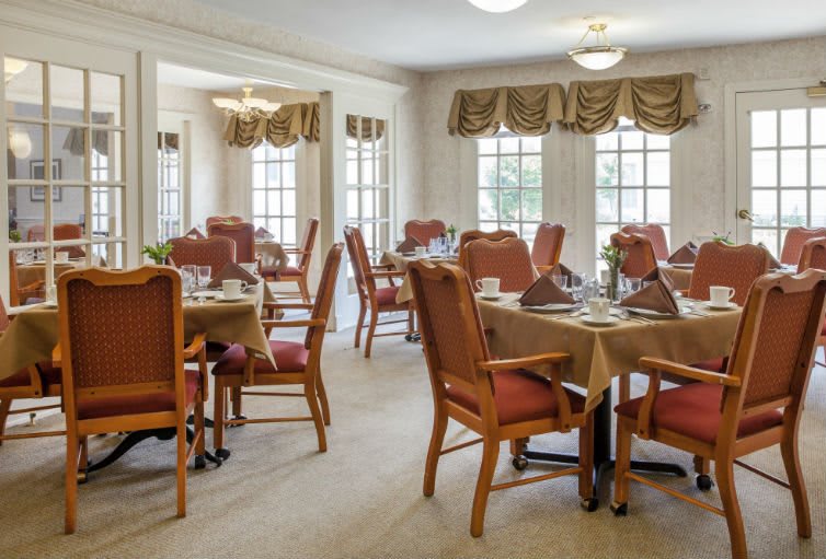 Elegant dining room with neatly arranged tables and natural lighting.