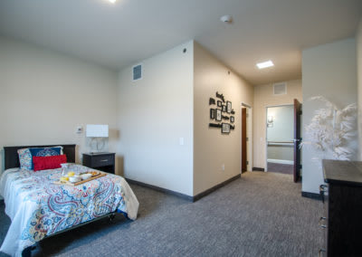 A modern apartment bedroom with carpeted flooring and contemporary decor.