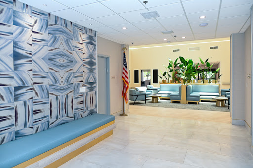 A modern waiting area featuring a stylish wall design, comfortable seating, and plants for a welcoming atmosphere.