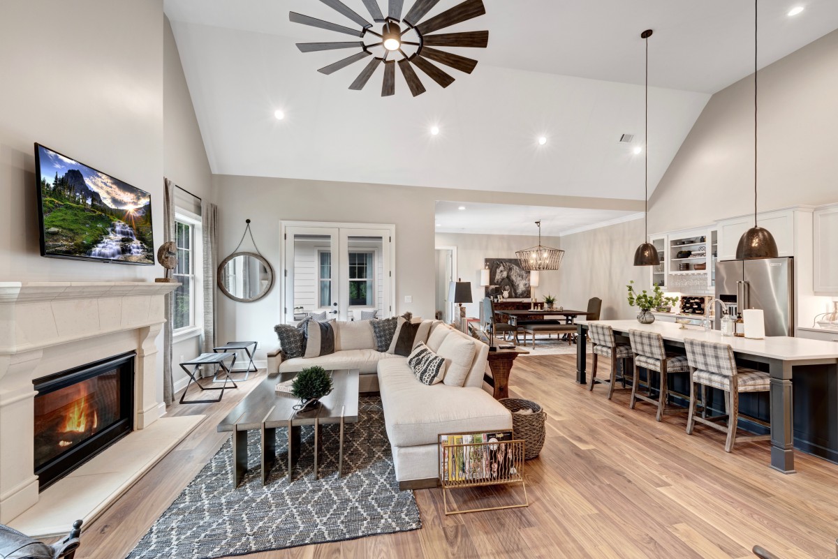 A modern open-concept living and dining area featuring neutral colors, wood flooring, and stylish furnishings.