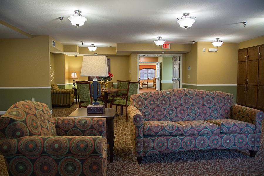 A cozy lobby area featuring patterned sofas and armchairs with soft lighting.
