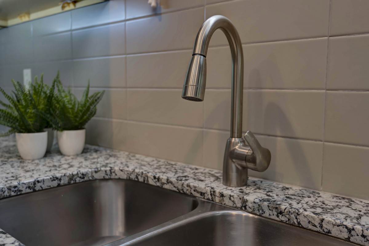 Modern kitchen sink with a sleek faucet and granite countertop.