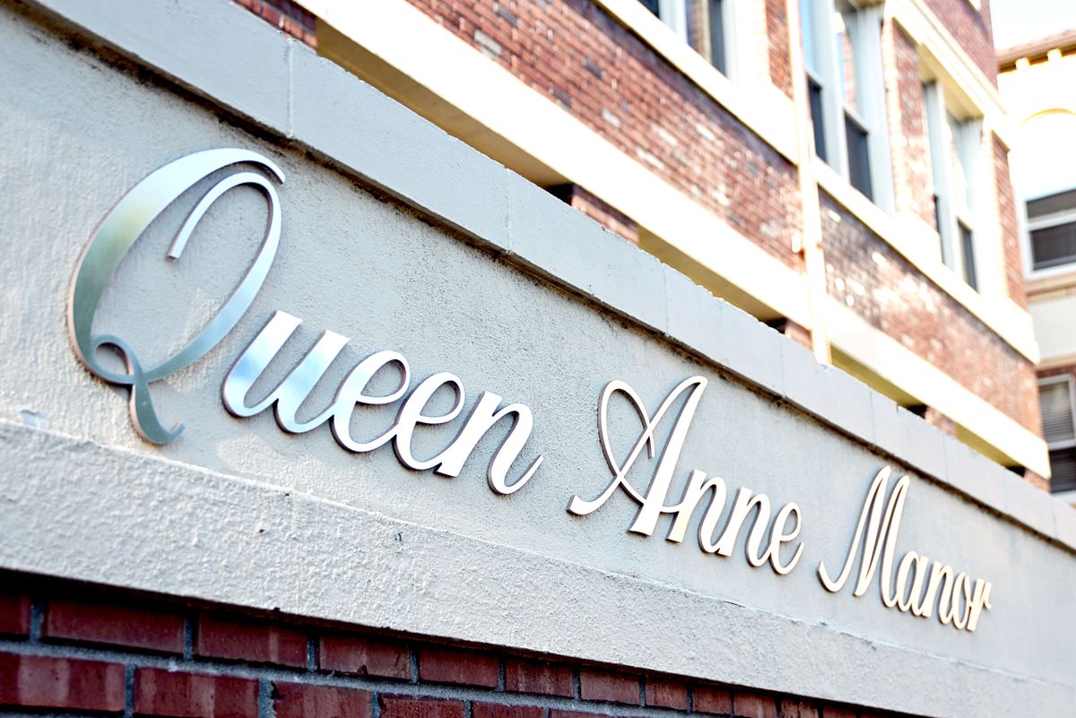 The exterior of a building featuring the signage 'Queen Anne Manor'.