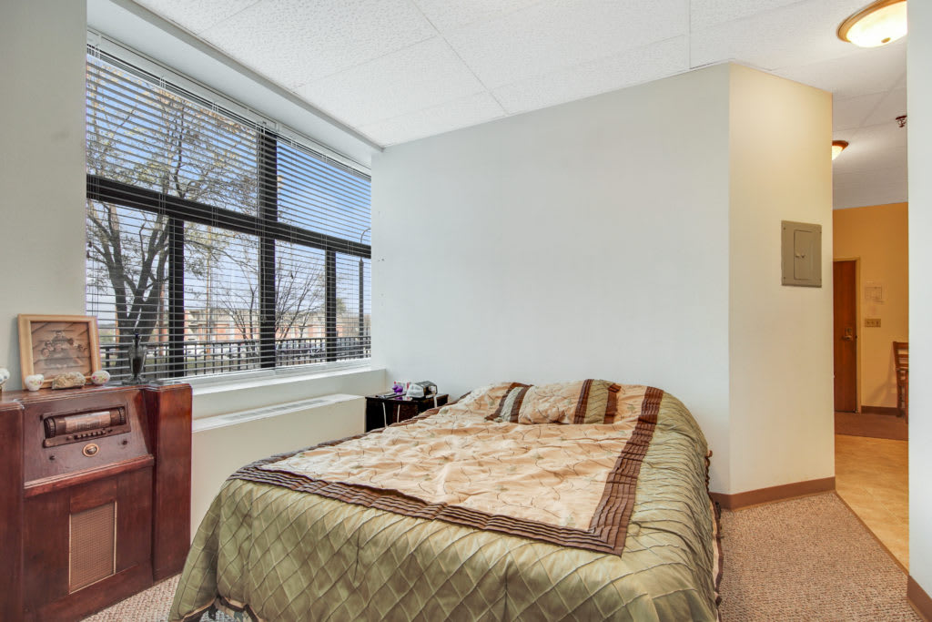 A cozy bedroom with a comfortable bed and large window.