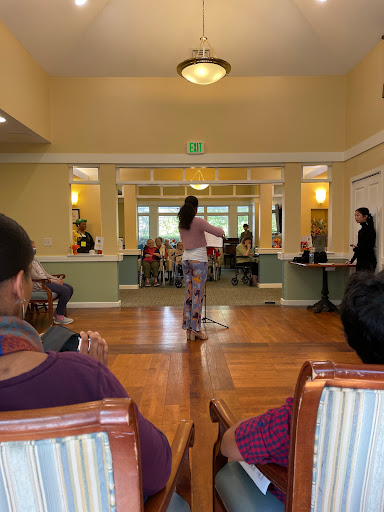 A dancer performs in front of an audience during a lively indoor event.