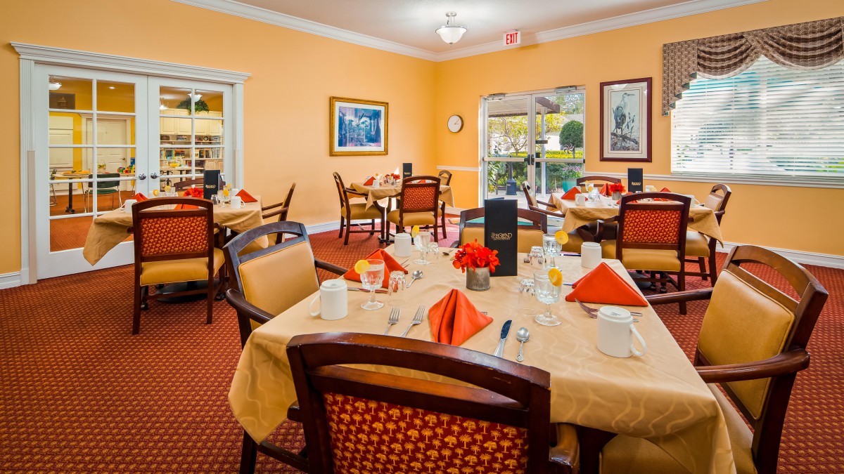 A warmly lit dining area with elegantly set tables and comfortable seating.