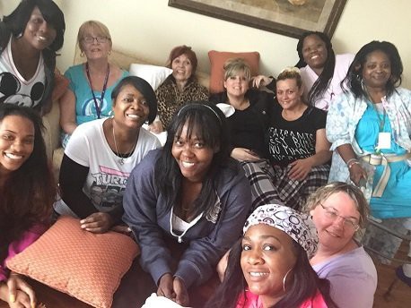A group of women gathered together indoors, smiling and enjoying their time.