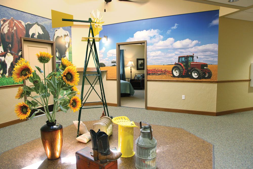 A farm-themed interior with sunflowers, a small windmill model, and a tractor mural on the wall.