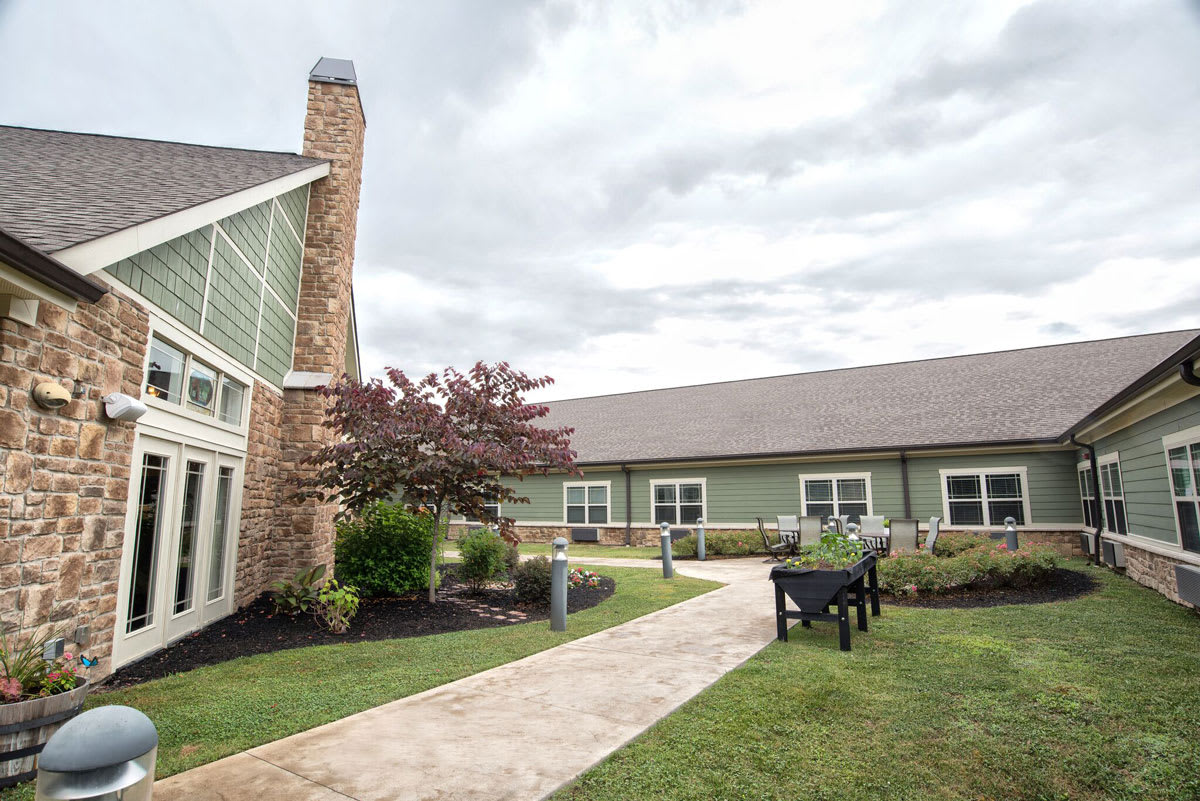 A peaceful garden setting with a modern building and pathway.