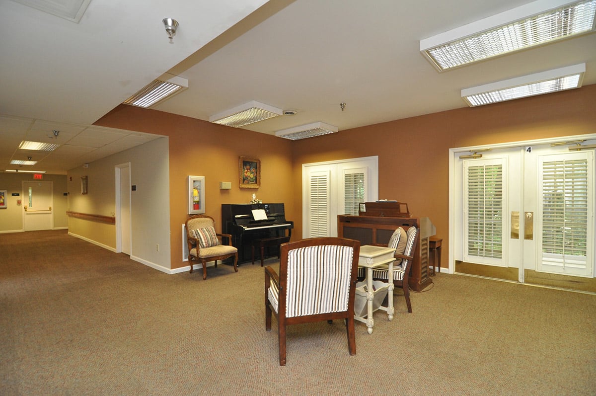 A cozy room with a piano and comfortable seating area.