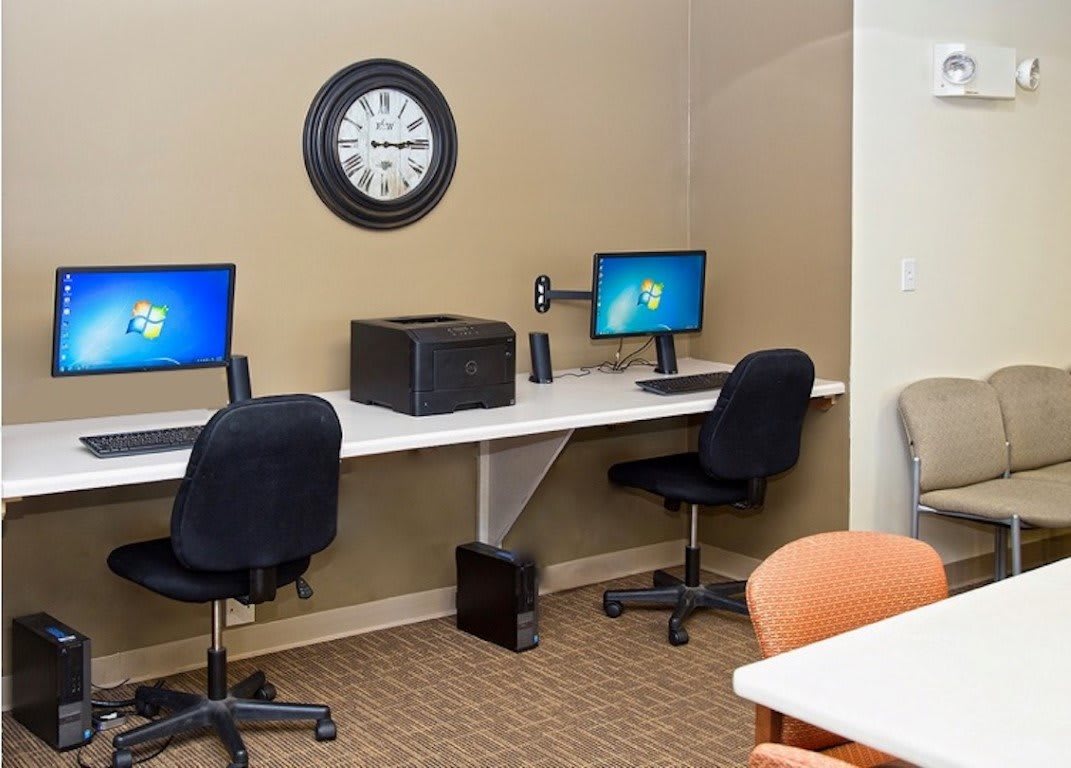 A modern office space with two computer workstations and a printer.