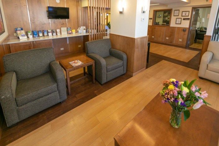 A comfortable hotel lobby with seating area and floral arrangement.