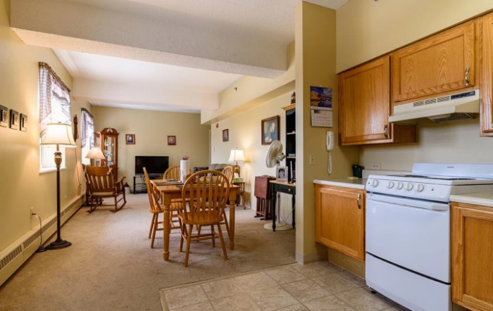 A cozy living space featuring a dining table, kitchen area, and comfortable seating.