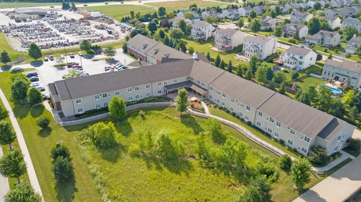 Aerial view of a large building surrounded by green space in a residential area.