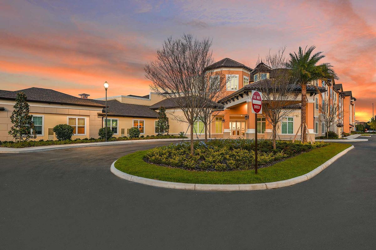 A picturesque residential building at sunset with well-maintained landscaping.