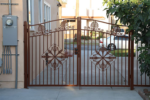 A beautifully designed wrought iron gate leading to a property.