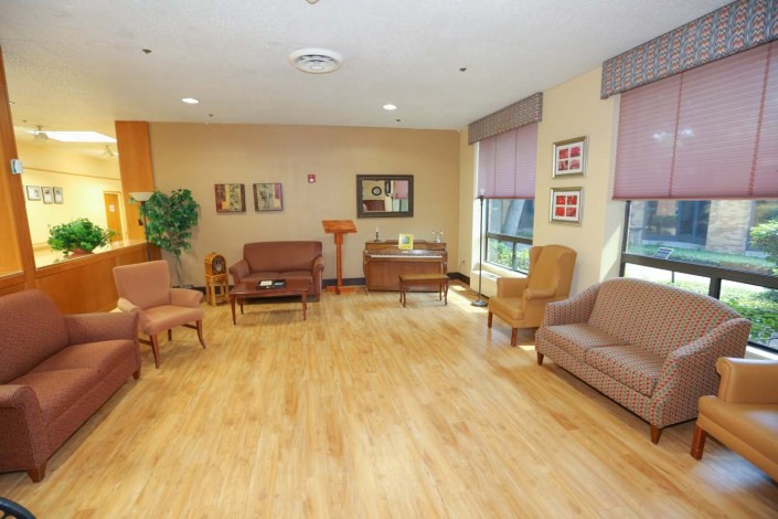 A cozy living room with comfortable seating and wooden flooring, adorned with various decorations.