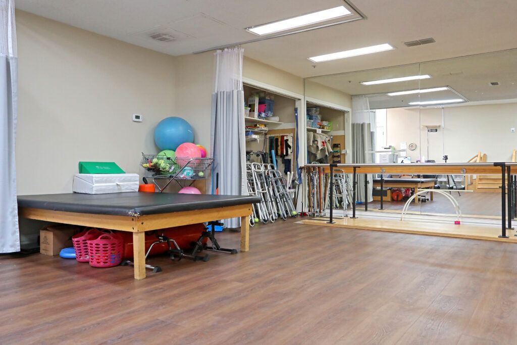 A physical therapy room equipped with exercise equipment and parallel bars.