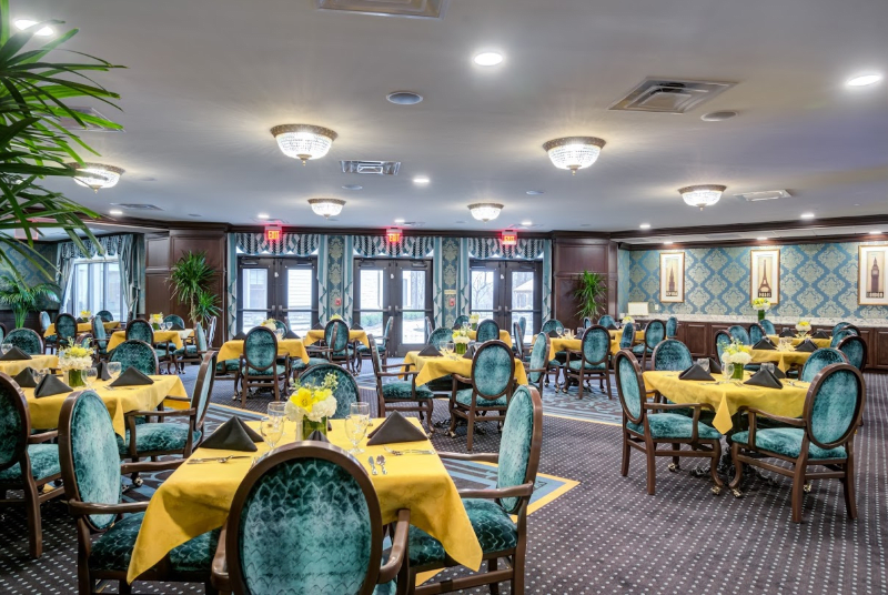 Elegant dining room with yellow table settings and plush blue chairs.