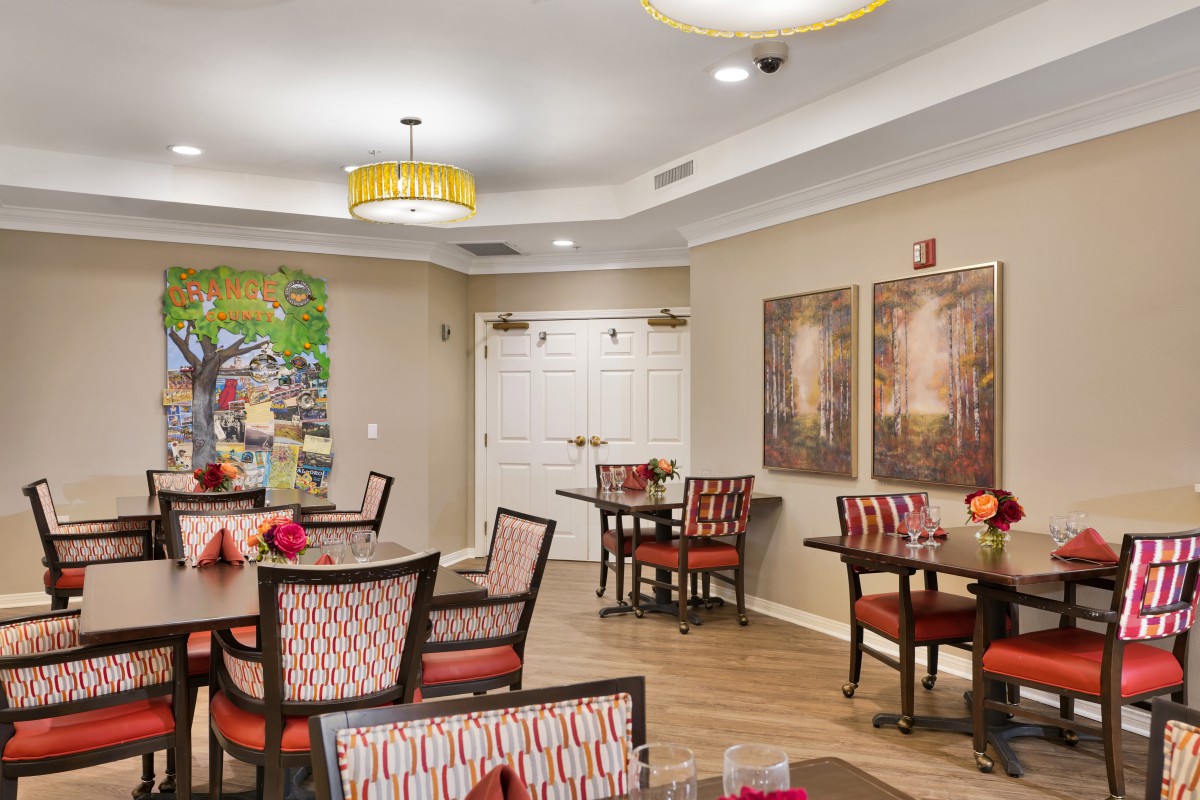 A well-decorated dining area featuring tables and chairs, with artwork on the walls and modern lighting.
