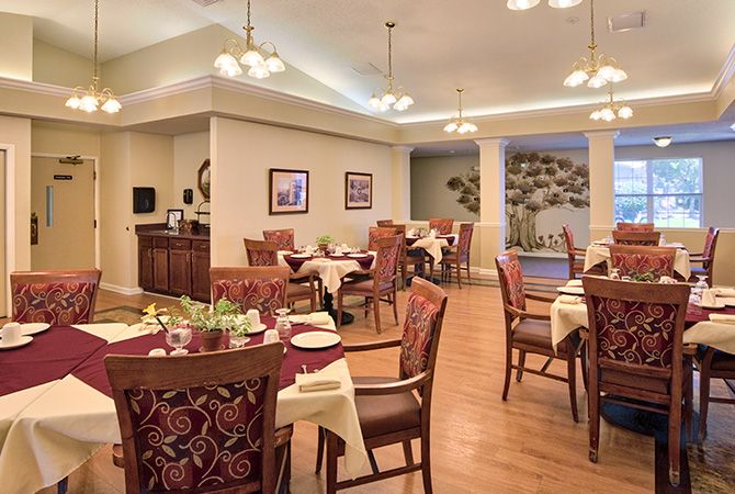A cozy dining room with elegantly set tables and warm lighting.