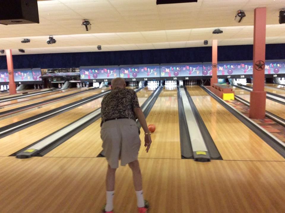 A person bowling at an indoor bowling alley.