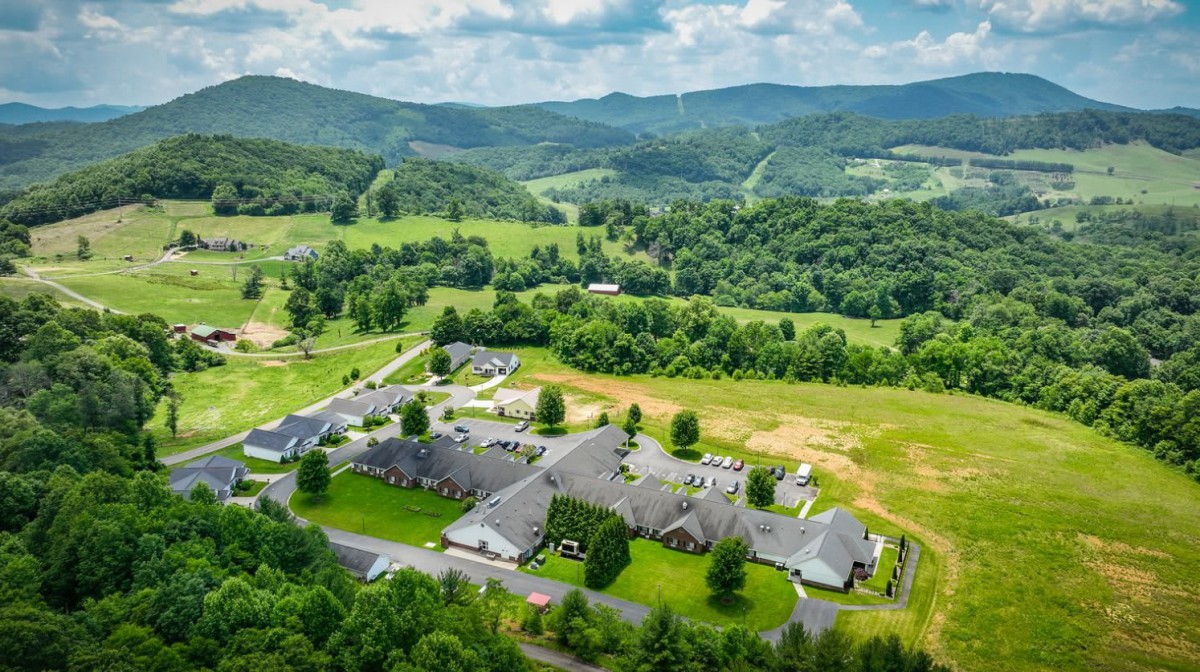 Aerial view of buildings nestled in a lush, mountainous landscape.